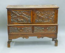 A 19th century carved oak side cupboard on stand. 98 cm wide.
