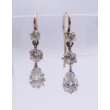 A pair of gold and diamond drop earrings. 1.75 cm high.