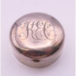 A small Edwardian silver round pill box, Birmingham 1900, top and bottom engraved with initials.