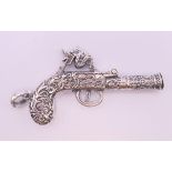 A silver gun form pendant. 6 cm long.