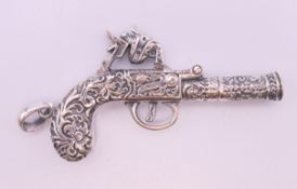 A silver gun form pendant. 6 cm long.