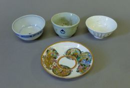 Three Oriental tea bowls and a saucer. The saucer 13 cm diameter.