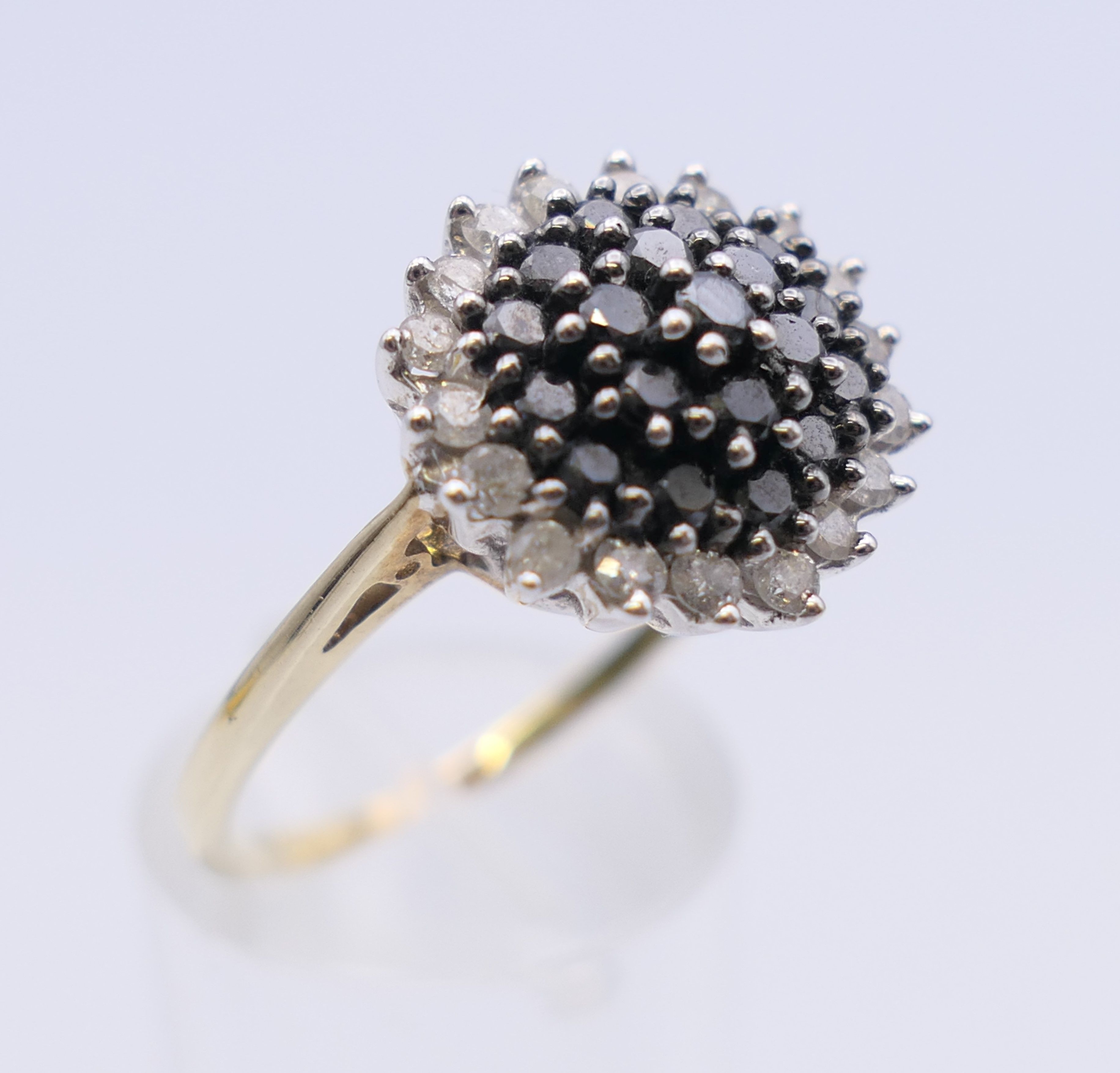A 9 ct gold black and white diamond ring. 15 mm diameter. Ring size T/U. 4.1 grammes total weight. - Image 3 of 7