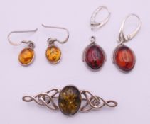 A collection of silver and amber earrings and brooches.