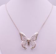 A silver butterfly pendant on a silver chain by Fiorelli. The pendant 4.5 cm wide.