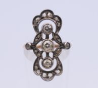 An unmarked Art Nouveau pierced scrolling diamond set ring. Ring size N/O. 3.4 grammes total weight.