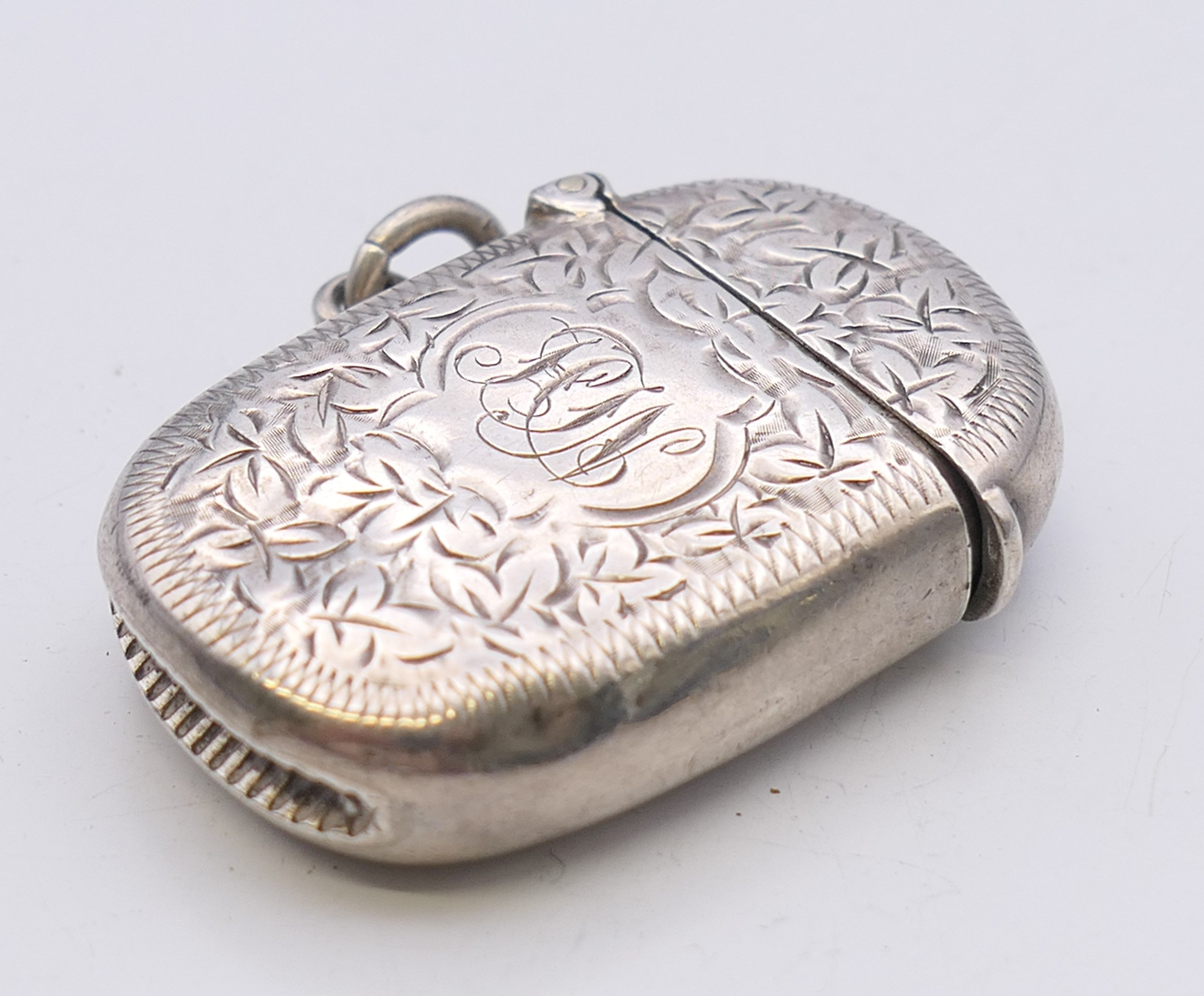 A Victorian silver vesta with leaf chased pattern, Birmingham 1898. 4 cm wide. 14.8 grammes. - Image 4 of 5