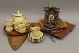 A quantity of wooden plates, a cuckoo clock and a tea set.
