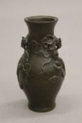 A small Chinese bronze vase decorated with dragons. 10 cm high.