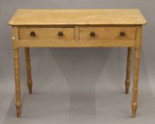 A 19th century pine two drawer side table. 97 cm wide.
