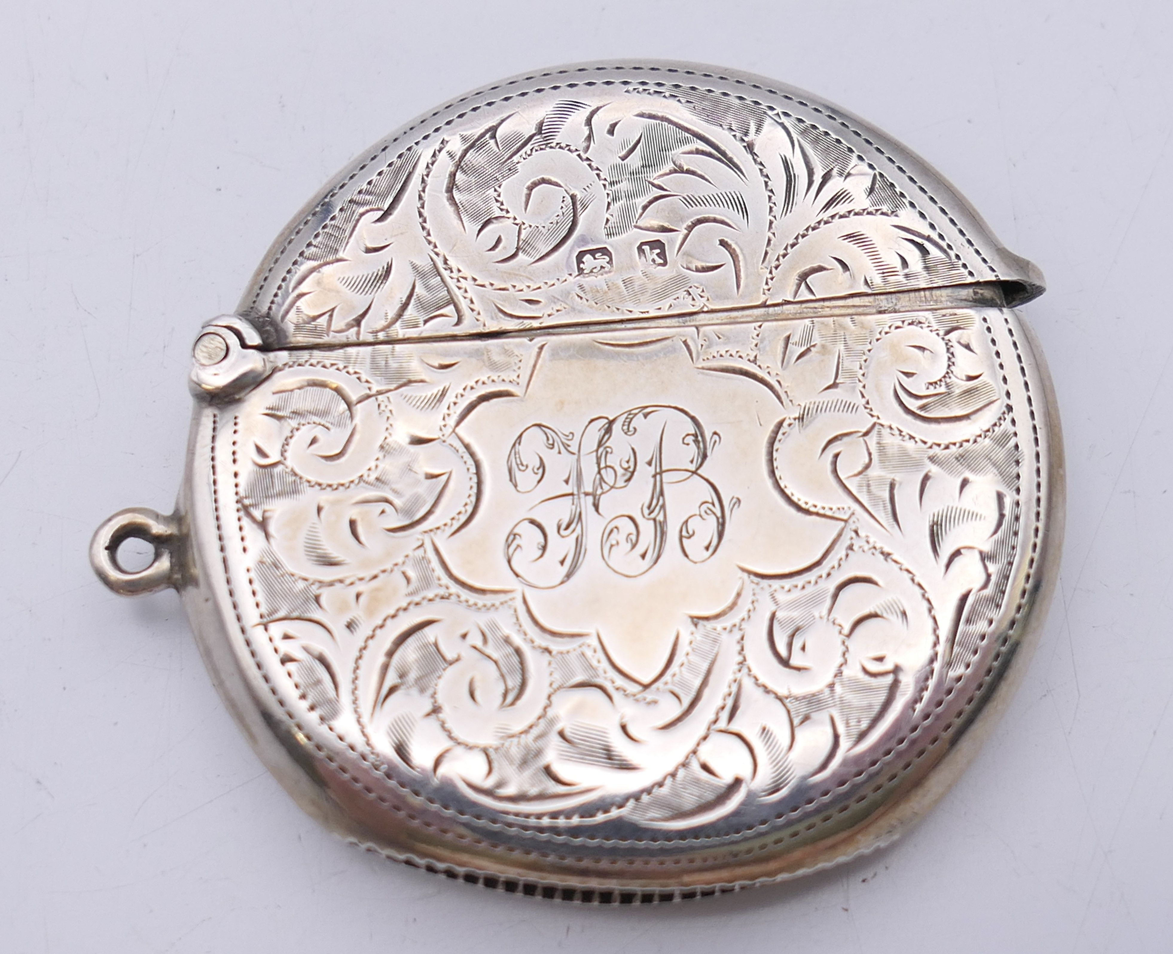 An Edwardian silver round vesta with leaf chased pattern, Birmingham 1909. 4.5 cm diameter. 15.