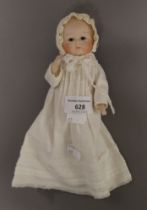 A 1930's miniature bisque headed doll. 17 cm high.
