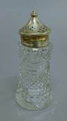 A silver topped cut glass sugar sifter. 15 cm high.