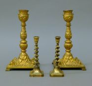 A pair of Victorian gilt bronze candlesticks and a small pair of brass candlesticks.