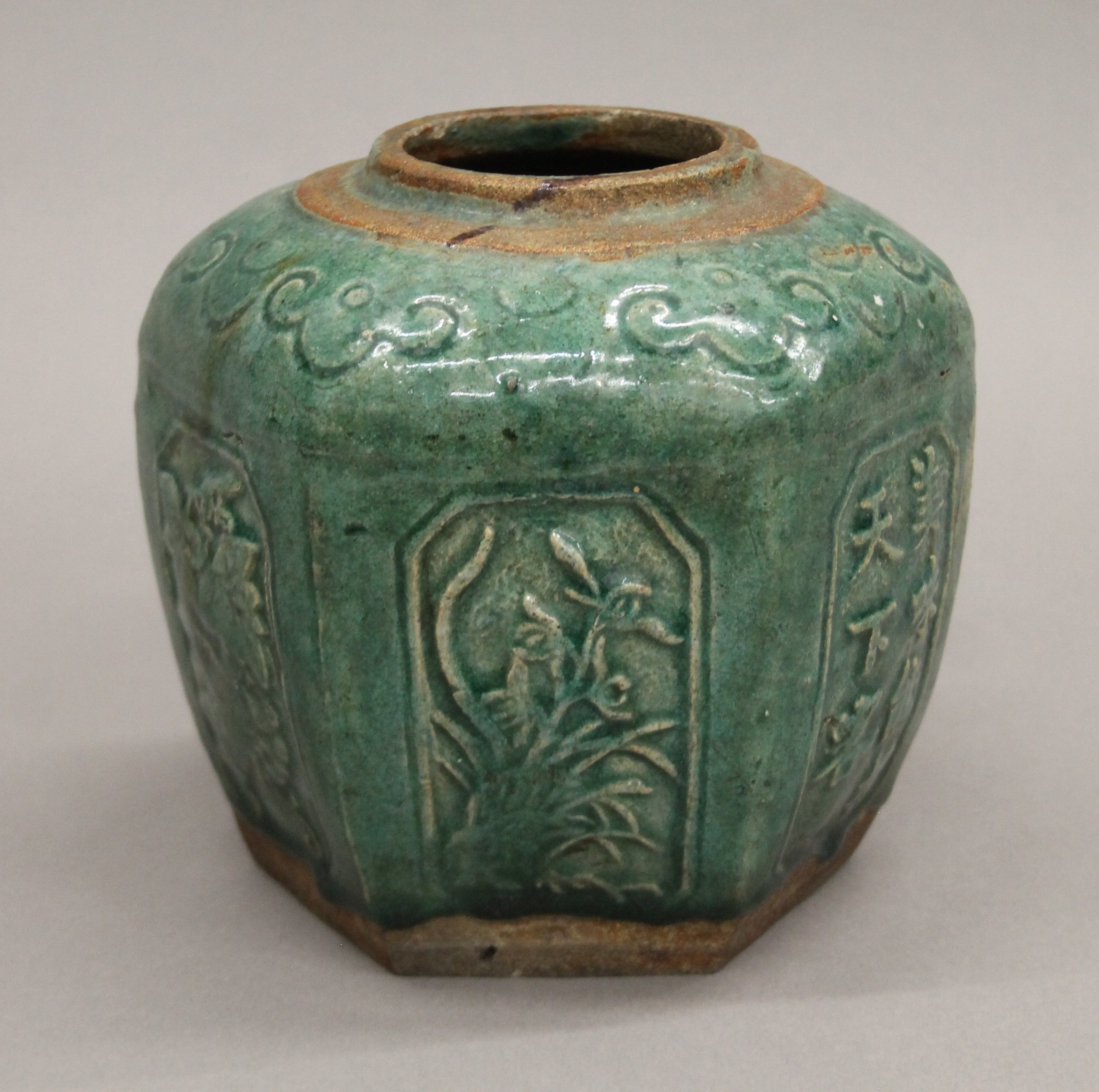 A Chinese green glazed jar, with panels of floral and calligraphy decoration. 14.5 cm high.