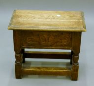An early 20th century carved oak box stool. 46.5 cm long.