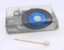 A music box motor and stick pin.
