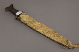 An Eastern dagger in hide scabbard. 47 cm long overall.