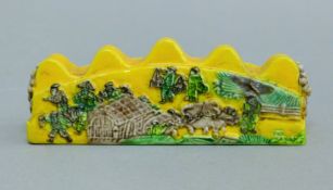 A Chinese yellow porcelain brush rest. 12.5 cm long.
