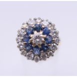 An 18 ct gold sapphire and diamond cluster ring. 16 mm diameter. Ring size N/O. 5.