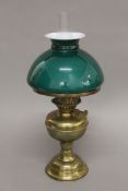 A brass oil lamp with green glass shade. 48 cm high overall.