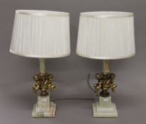 A pair of onyx and cherub form table lamps. 54 cm high including shades.