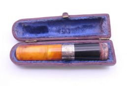 A cased amber cigar holder with silver collar. 8 cm long.