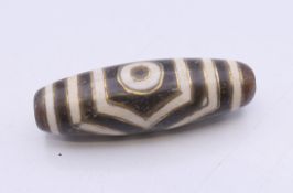 A gold inlaid dzi bead. 3.75 cm long.