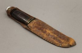 A dagger in a leather sheath. 26.5 cm long.