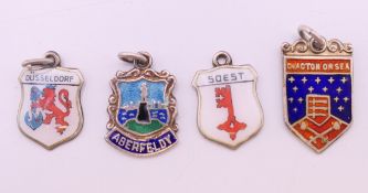 Four silver enamel charms. The largest 2 cm high.