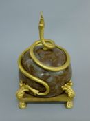 A marble and gilt metal sculpture with entwined snake. 30 cm high.