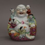 A Chinese figure of laughing Buddha and children. 15 cm high.