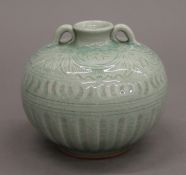 A celadon ground bulbous porcelain vase. 11 cm high.