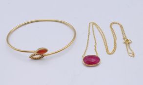 A silver gilt bangle and necklace. The bangle 7 cm wide.