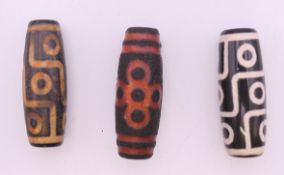 Three agate dzi beads. Each approximately 4 cm long.