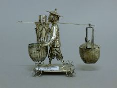 A Chinese silver cruet set formed as a man carrying water buckets. 11 cm high. 160.