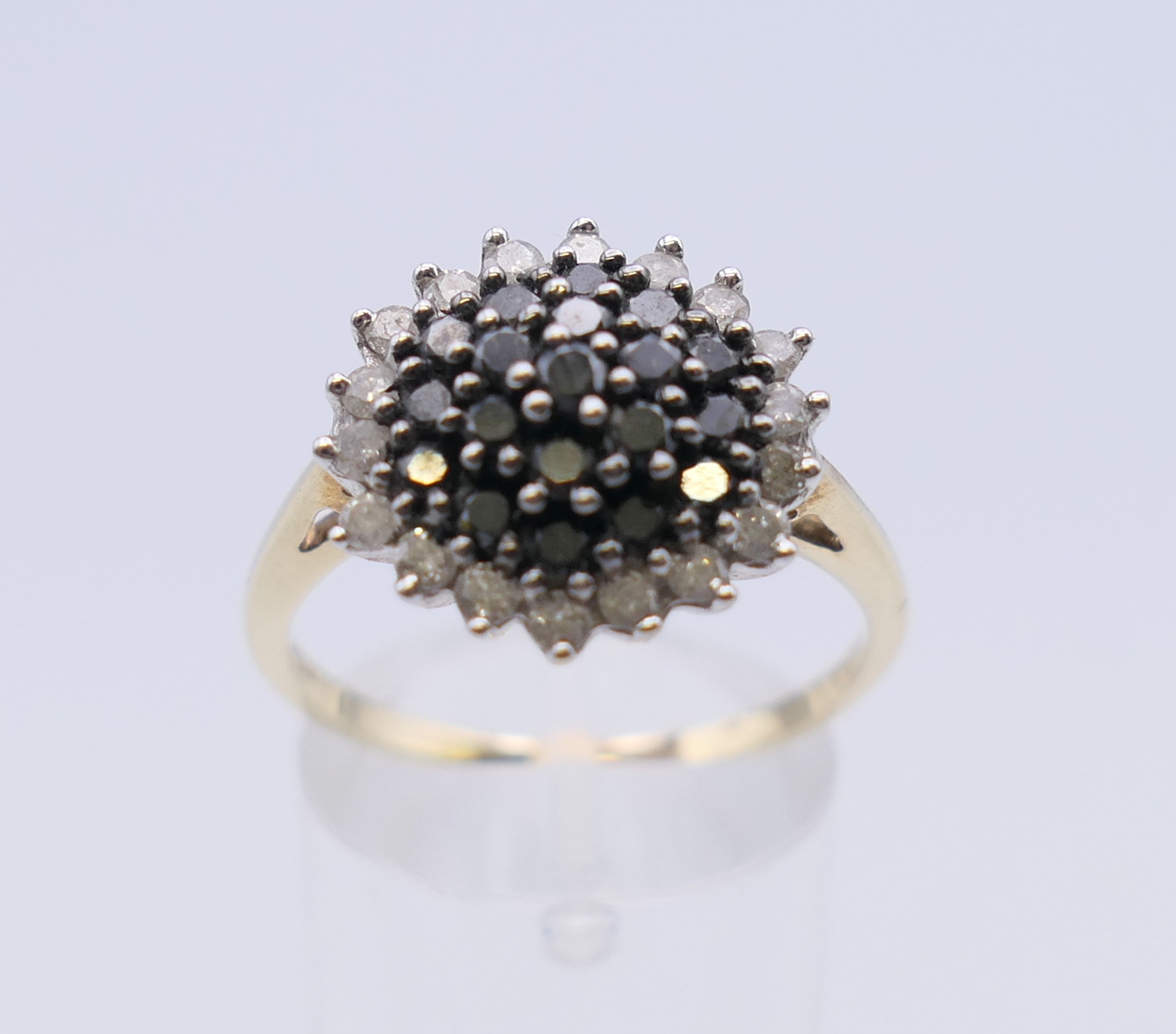 A 9 ct gold black and white diamond ring. 15 mm diameter. Ring size T/U. 4.1 grammes total weight. - Image 2 of 7