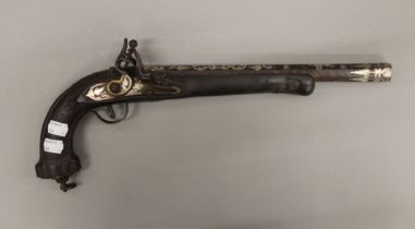 An unmarked white metal inlaid pistol. 44 cm long.