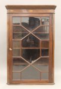 A 19th century inlaid mahogany glazed hanging corner cabinet.