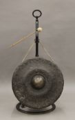 A large gong mounted on wrought iron stand formed as a snake. 98 cm high.