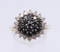A 9 ct gold black and white diamond ring. 15 mm diameter. Ring size T/U. 4.1 grammes total weight.