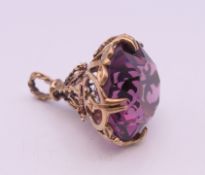 A 9 ct gold and amethyst fob. 2.5 cm high. 7.7 grammes total weight.