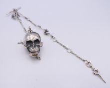 A silver skull and chain. The skull 4 cm long.