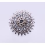 An 18 ct white gold diamond cluster ring. Ring size O. 6.3 grammes total weight.