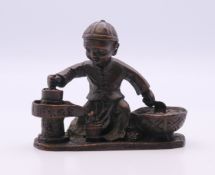 A bronze model of a boy cooking. 6 cm high.