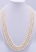 A three strand cultured pearl necklace with an 18 ct gold clasp set with circular and marquise