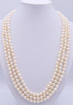 A three strand cultured pearl necklace with an 18 ct gold clasp set with circular and marquise