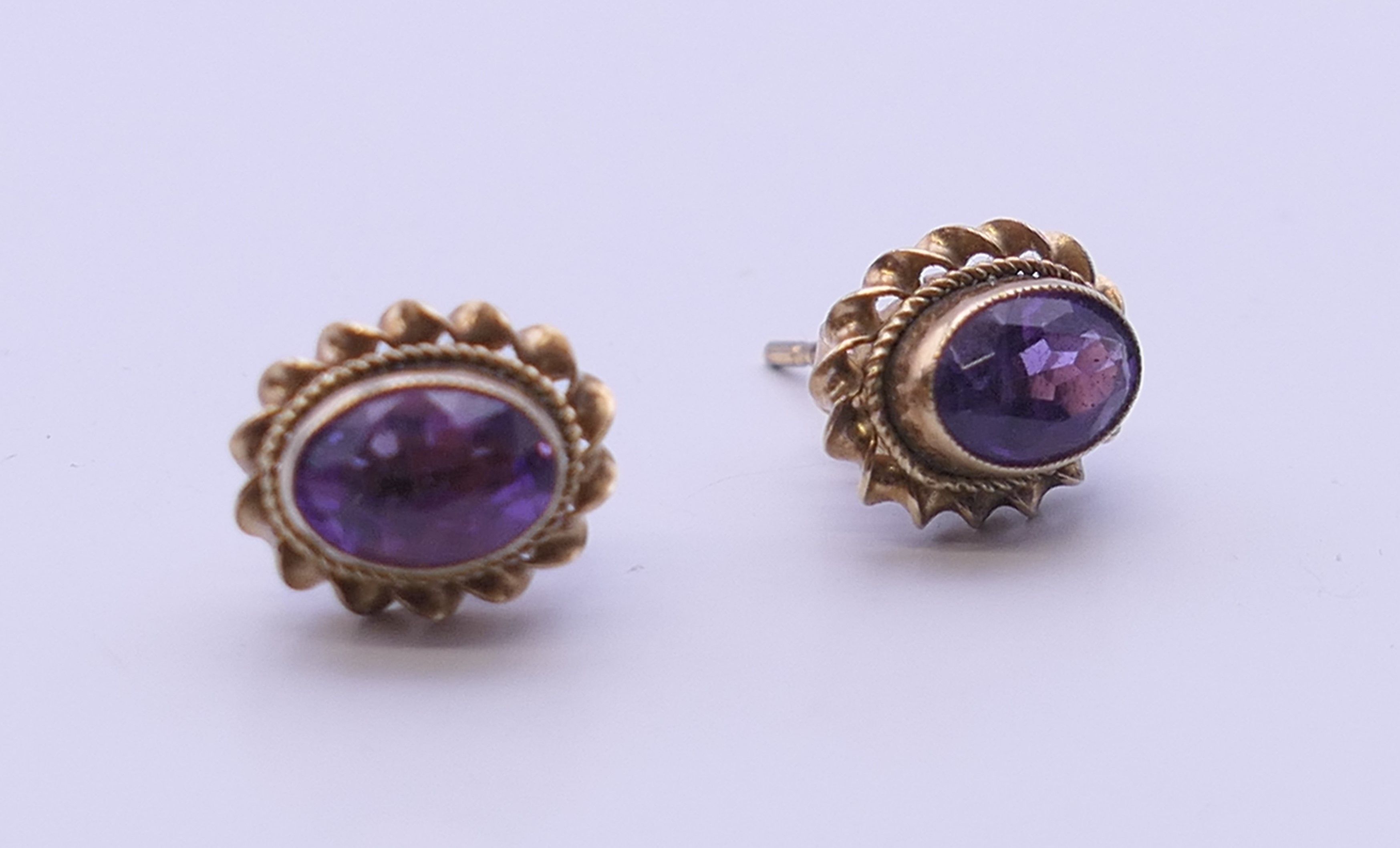 A pair of 9 ct gold and amethyst earrings. 9 mm high.