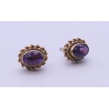 A pair of 9 ct gold and amethyst earrings. 9 mm high.