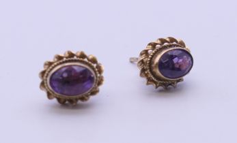A pair of 9 ct gold and amethyst earrings. 9 mm high.